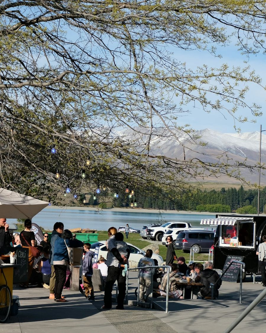 People gathered around a yellow food cart at Lake Tekapo